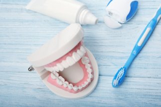 Dental-jaw-model-and-tooth-brush-with-paste-on-wooden-background.jpg